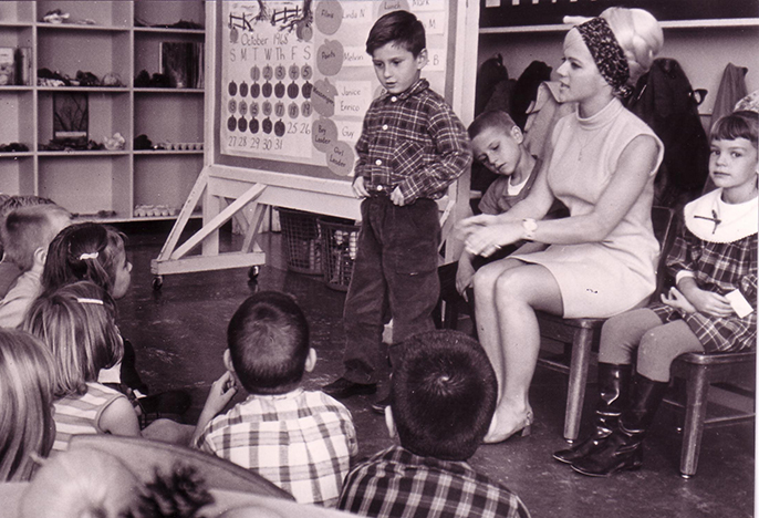 Female teacher sitting at head of a circle circa 1970s
